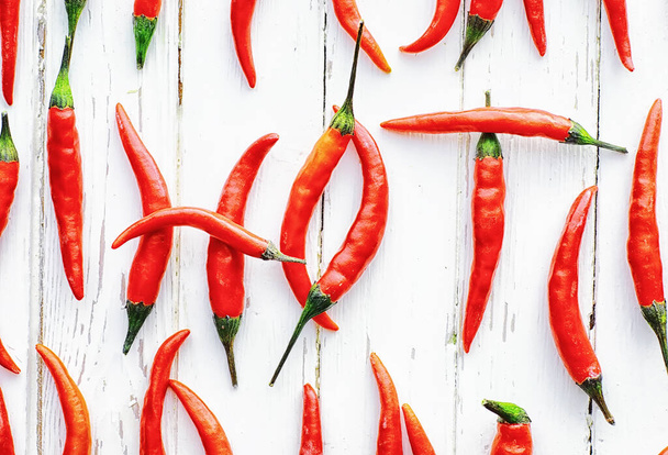 Hot red pepper on white wooden vintage background. - Фото, изображение