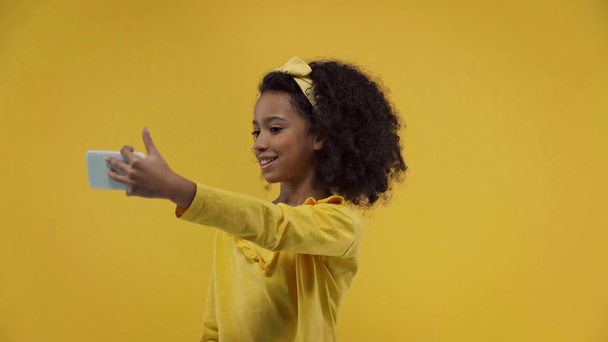 happy african american kid taking selfie isolated on yellow  - Video, Çekim