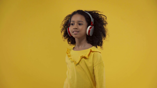 african american kid listening music and dancing isolated on yellow  - Video