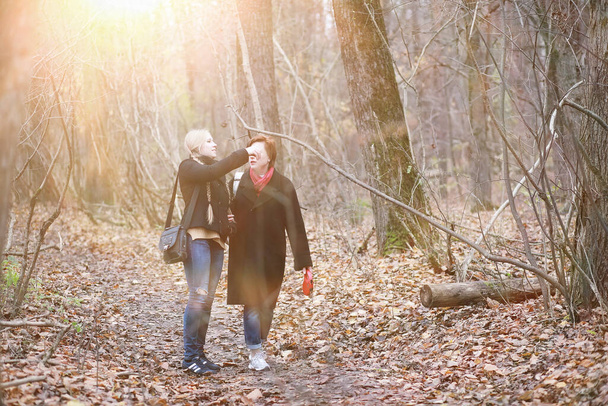 mooie vrouw met tiener dochter op een wandeling in de herfst tuin - Foto, afbeelding