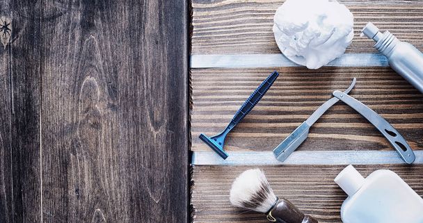 Shaving accessories on a wooden texture background. Tools. Disposable shaving machine, brush, foam hazard razor. - Foto, afbeelding