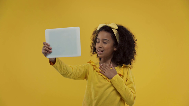 Αφροαμερικανό παιδί που έχει βιντεοκλήση απομονωμένη στο κίτρινο  - Πλάνα, βίντεο