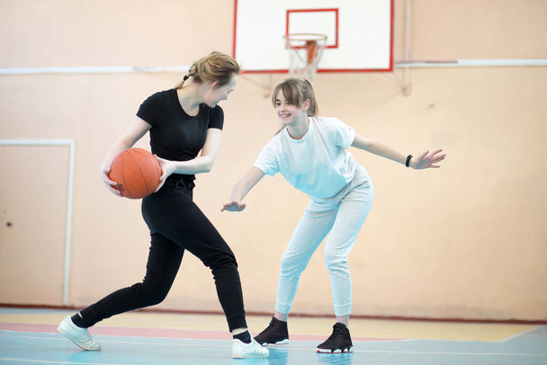 female young students playing basketball in the gym  - Foto, Bild