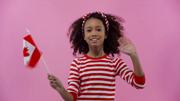 Афріканське американське дитя з канадійським прапором ізольованим на рожевому - Кадри, відео