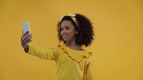 lindo africano americano niño teniendo video llamada aislado en amarillo
  - Metraje, vídeo