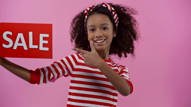 criança afro-americana com etiqueta de venda isolada em rosa
 - Filmagem, Vídeo