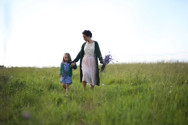 Beautiful young mother with daughter walking on a rural road - Fotografie, Obrázek
