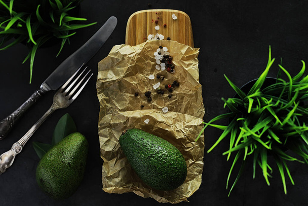 Ricette di cucina avocado. Avocado verde maturo su un tagliere di legno che serve. - Foto, immagini