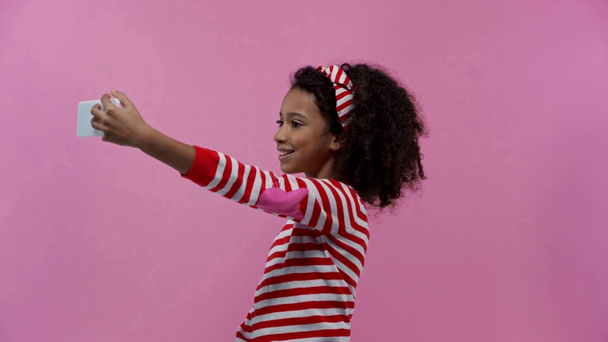 Χαρούμενο αφροαμερικανό παιδί που βγάζει σέλφι απομονωμένο στο ροζ.  - Πλάνα, βίντεο