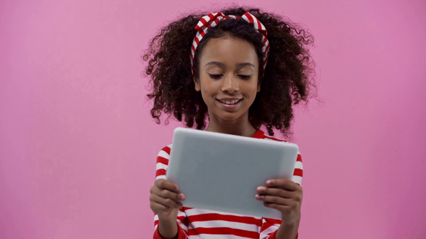 Αφροαμερικανό παιδί που χρησιμοποιεί ψηφιακό δισκίο απομονωμένο σε ροζ  - Πλάνα, βίντεο