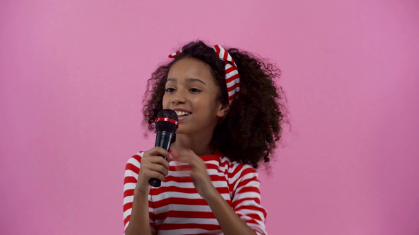 Χαρούμενο αφροαμερικάνικο παιδί που τραγουδά απομονωμένο στο ροζ.  - Πλάνα, βίντεο