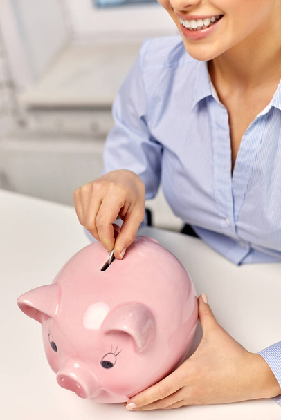 businesswoman with piggy bank and coin at office - Foto, Imagen