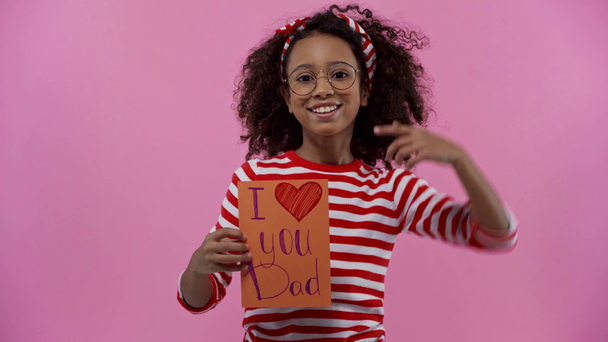 african american child holding greeting card isolated on pink  - Felvétel, videó