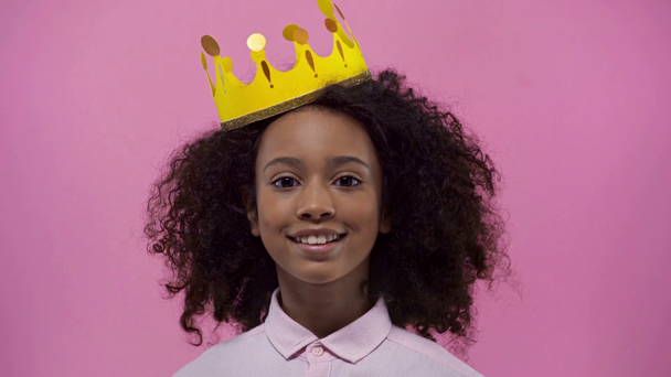 happy african american kid with cardboard crown isolated on pink  - Felvétel, videó