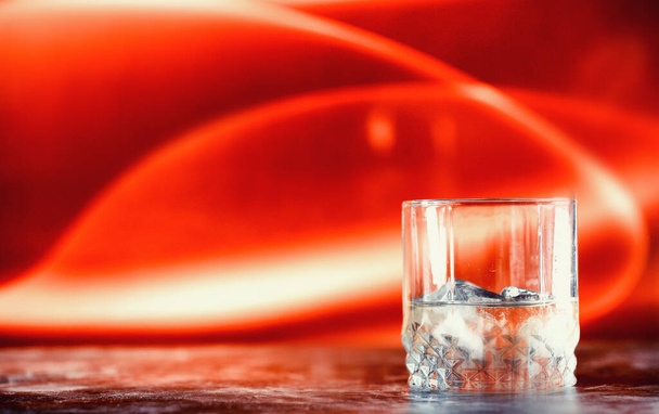 A glass of hard alcohol with ice on a bar counter. Whiskey with soda in glass. Advertising alcoholic drink. - Fotoğraf, Görsel