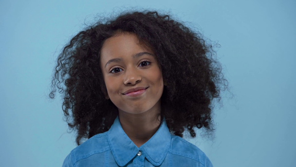 fröhliches afrikanisch-amerikanisches Kind lächelt isoliert auf blau  - Filmmaterial, Video