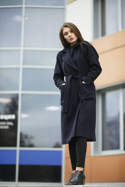 Belle fille dans un manteau dans les affaires du centre-ville du nuage - Photo, image