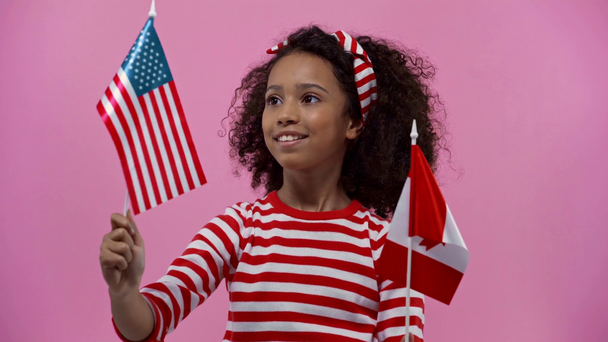 Pembe üzerinde Amerika ve Kanada bayrakları olan Afrikalı Amerikalı çocuk. - Video, Çekim