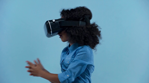 criança afro-americana em fone de ouvido de realidade virtual isolado em azul
  - Filmagem, Vídeo