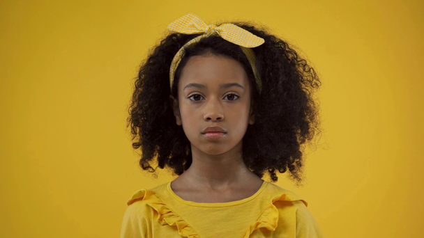lindo africano americano niño mirando cámara aislado en amarillo
 - Imágenes, Vídeo