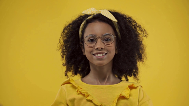 emotional african american kid in glasses isolated on yellow - Materiał filmowy, wideo