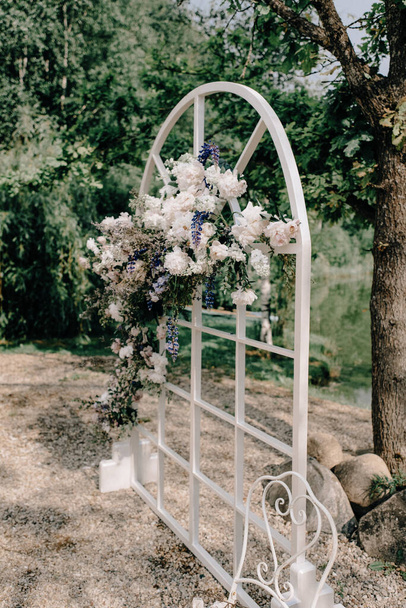 Wedding. Wedding ceremony. Arch. Arch, decorated with pink and white flowers standing in the woods, in the wedding ceremony - Photo, image