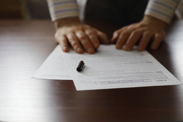 Geschäftstreffen. Ein Mann unterschreibt einen Vertrag. Männliche Hand mit Stift macht sich Notizen im Büro. - Foto, Bild