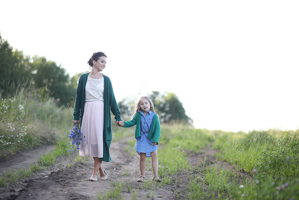 Kaunis nuori äiti tyttärensä kanssa kävely maaseudulla
 - Valokuva, kuva