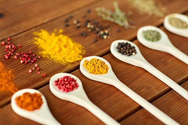 spoons with different spices on wooden table - 写真・画像