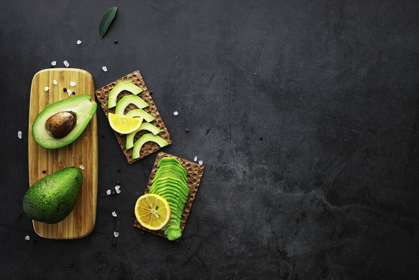 Avocado cooking recipes. Ripe green avocado on a wooden cutting board serving. - Foto, Imagem