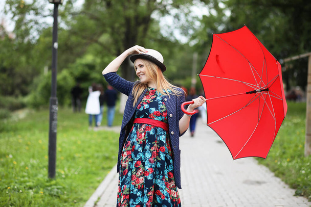 Tyttö kadulla sateenvarjon kanssa kävelylle kesäpäivänä
 - Valokuva, kuva