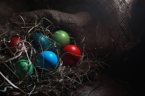 Easter painted eggs on burlap and stra - Valokuva, kuva