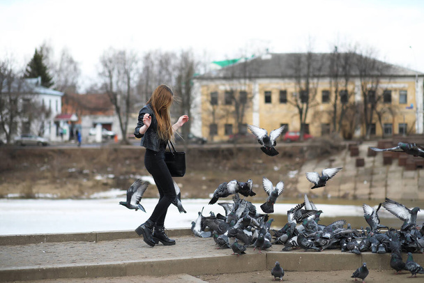 公園を散歩している女の子と鳩の群れ - 写真・画像