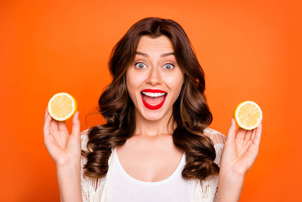 Photo of curly wavy cheerful positive nice charming pretty sweet youngster excited about having bought discounted lemon isolated over vivid color background - Фото, изображение