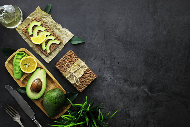 Avocado cooking recipes. Ripe green avocado on a wooden cutting board serving. - Foto, immagini