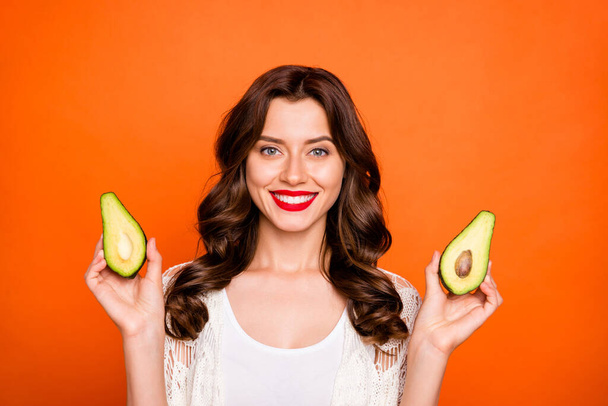 Photo of cheerful positive cute nice toothy beaming girlfriend showing you two halves of one avocado isolated over vivid color background - Фото, изображение