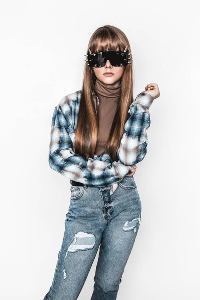 Fashion portrait of beautiful young girl with smooth hair. Girl in blouse and jeans. Clothing and hairstyle. Teenager with sunglasses. High fashion look. Glamour stylish hipster young model - Zdjęcie, obraz