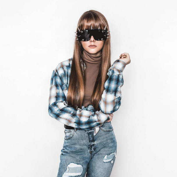 Fashion portrait of beautiful young girl with smooth hair. Girl in blouse and jeans. Clothing and hairstyle. Teenager with sunglasses. High fashion look. Glamour stylish hipster young model - Foto, afbeelding