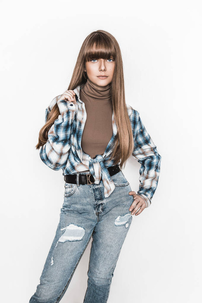 Fashion portrait of beautiful young girl with smooth hair. Girl in blouse and jeans. Clothing and bangs hairstyle. High fashion look. School teenager. Glamour stylish hipster young model - Photo, Image
