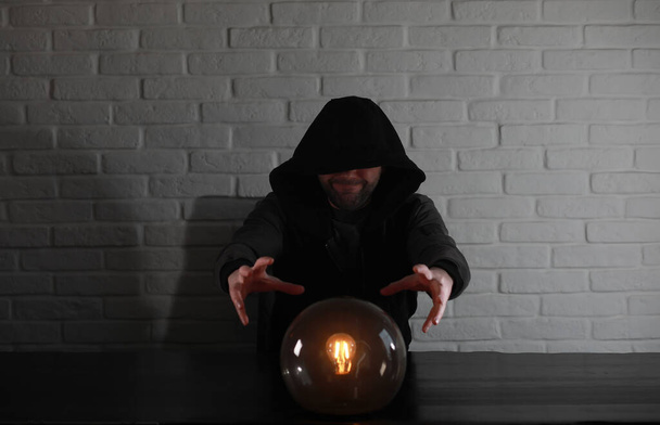 A man with a fortune teller ball at the table - Foto, Bild