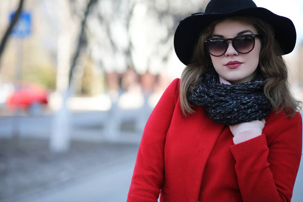 Pretty girl on a walk in a red coat in the city - Zdjęcie, obraz