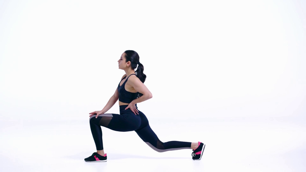 zijaanzicht van sportvrouw stretching op wit   - Video