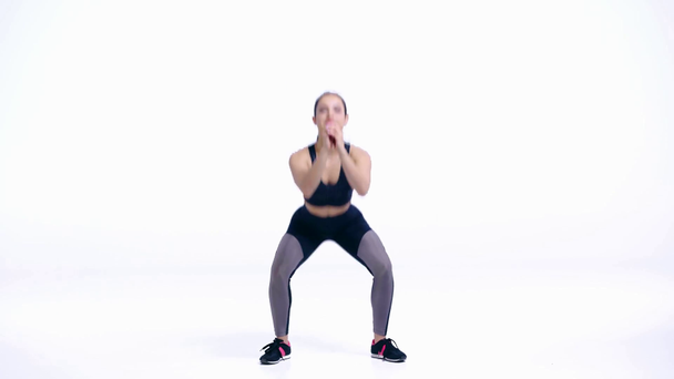 happy sportswoman doing squat exercise on white   - Materiaali, video