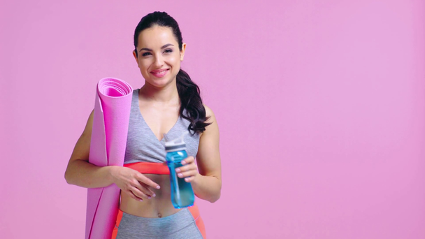 happy sportswoman drinking water isolated on pink  - Footage, Video
