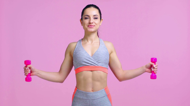 mujer feliz haciendo ejercicio con mancuernas aisladas en rosa  - Metraje, vídeo
