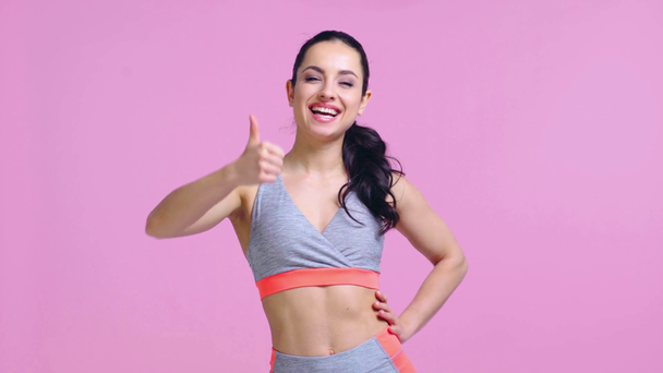 smiling sportswoman showing thumb up isolated on pink  - Footage, Video
