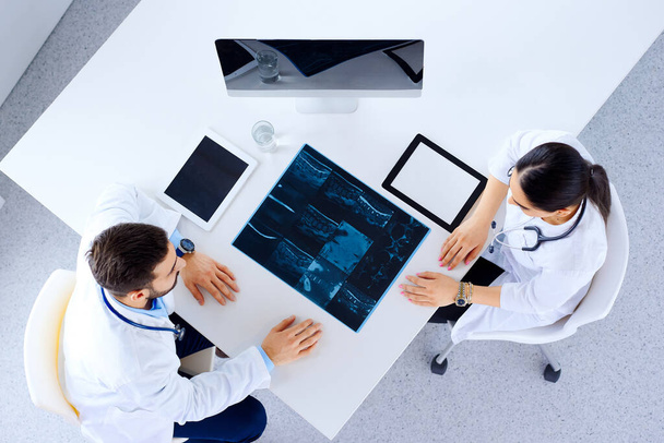 病院、医療、医療、手術の概念で脊椎X線とクリップボードを持つ医師または外科医  - 写真・画像