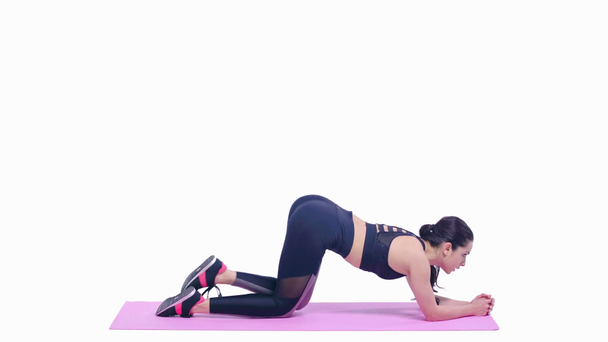 boční pohled sportovkyně cvičení na fitness podložku izolované na bílém   - Záběry, video