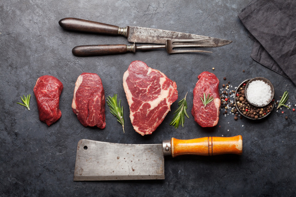 Variété de steaks de bœuf cru frais avec des épices sur la table en pierre. Vue du dessus plat lay
 - Photo, image