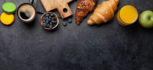 Breakfast with coffee, orange juice, berries and croissant. Top view on stone table with copy space. Flat lay - Фото, зображення
